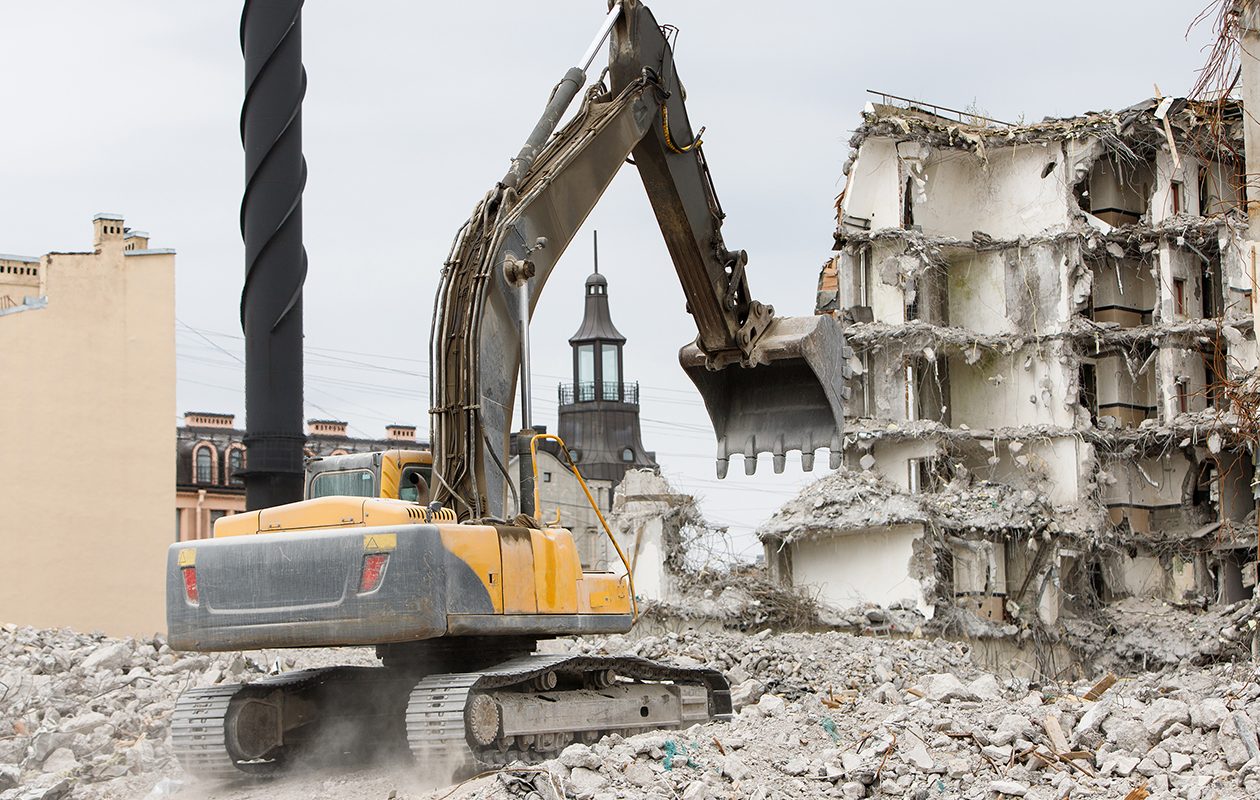 Abriss des ehemaligen Hotels für einen Neubau, Einsatz eines speziellen hydraulischen Abrissbaggers. Demontage des Hauses.